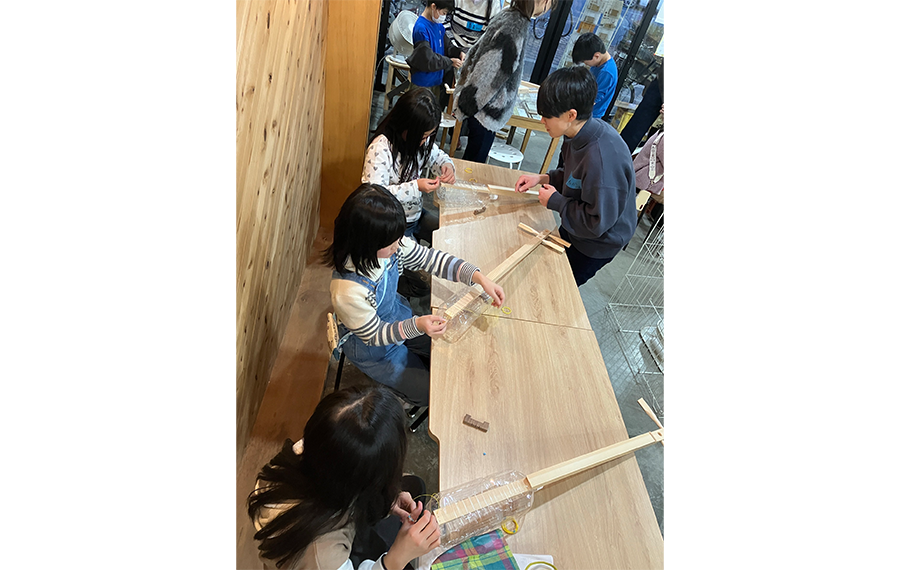 ペットボトル三味線を制作する子ども
